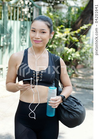 Sportswoman Listening to Music on Smartphone Sportswoman Listening to Music on Smartphone 84201641