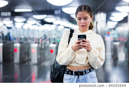 Confident girl entered the subway, passing through the turnstile Confident girl entered the subway, passing through the turnstile 84201644