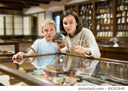 Woman and boy exploring artworks in museum Woman and boy exploring artworks in museum 84201646