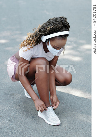 Young Woman Tying Shoe Laces 84201781
