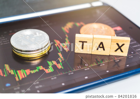 Cryptocurrencies with TAX word and stock chart candlestick on tablets background Cryptocurrencies with TAX word and stock chart candlestick on tablets background 84201816