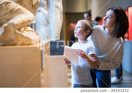 Woman and boy visiting sculptures exhibition 84201832