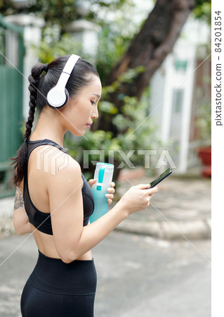 Female Jogger Choosing Music Female Jogger Choosing Music 84201854