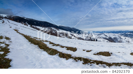 Mountain peak with snow blow by wind. Winter landscape. Cold day, with snow. 84202370