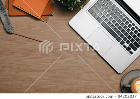 Top view computer laptop, coffee cup and houseplant on wooden table. Top view computer laptop, coffee cup and houseplant on wooden table. 84202837