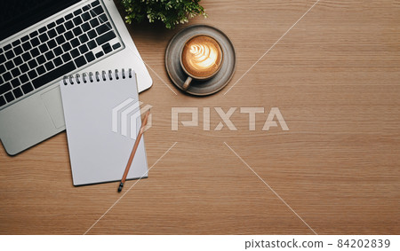Empty notebook, laptop and cup of hot coffee on wooden desk. Empty notebook, laptop and cup of hot coffee on wooden desk. 84202839