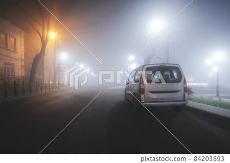 Car on a foggy autumn night in the city 84203893