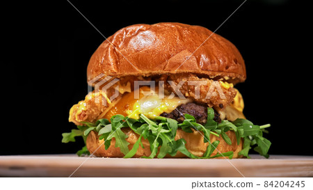 Craft burger is cooking on black background. Consist: sauce, aru Craft burger is cooking on black background. Consist: sauce, aru 84204245