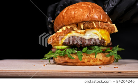 Craft burger is cooking on black background. Consist: sauce, aru Craft burger is cooking on black background. Consist: sauce, aru 84204246