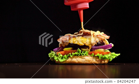 Craft burger is cooking on black background. Consist: sauce, let Craft burger is cooking on black background. Consist: sauce, let 84204247