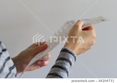 Female hand checking receipt 2 84204731
