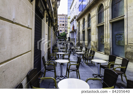 chairs and tables in front of an outdoor street cafe terrace 84205640