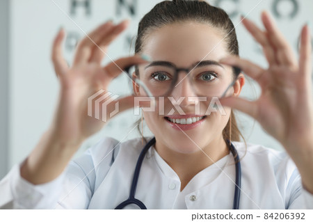 Woman eye doctor with eye test chart on background Woman eye doctor with eye test chart on background 84206392