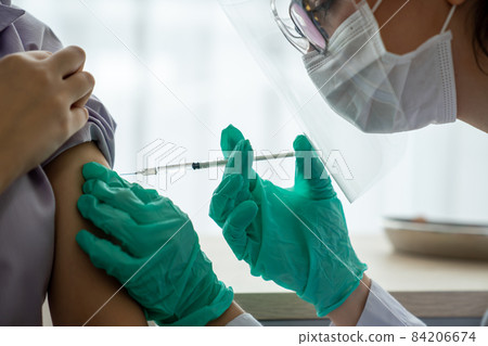 Young woman visits skillful doctor at hospital for vaccination Young woman visits skillful doctor at hospital for vaccination 84206674