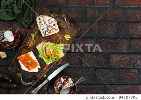 healthy sandwiches with smoked salmon avocado cucumber cream cheese on rye bread on dark background 84207706
