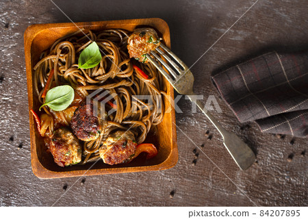 Plate soba with fried cutlets and sauce on a table. 84207895