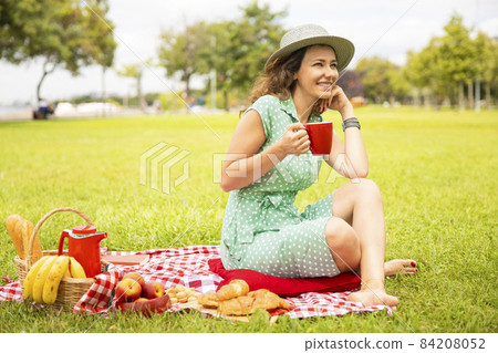 Beautiful young woman having picnic. 84208052