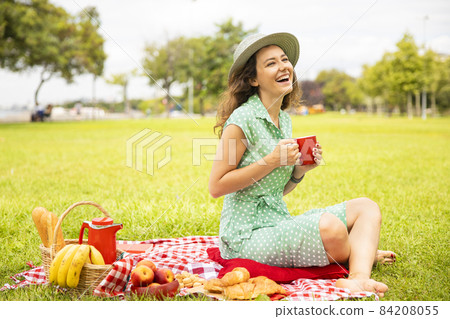 Beautiful young woman having picnic. 84208055