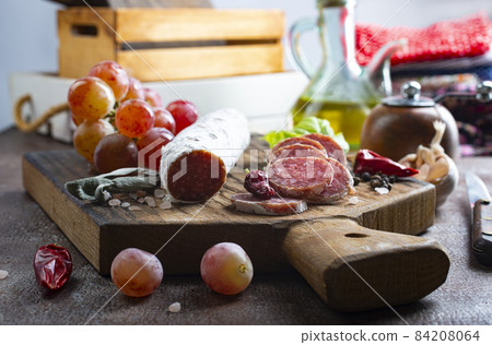 salami with spice on board, salami and fresh grape 84208064