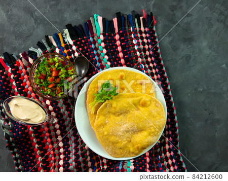 Homemade corn flatbread with cilantro green tomato salsa. Handmade mexican tortilla authentic textile Traditional Indian Homemade corn flatbread with cilantro green tomato salsa. Handmade mexican tortilla authentic textile Traditional Indian 84212600