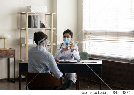 Indian woman doctor physician in mask consulting African American patient 84213825