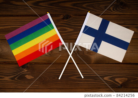 Rainbow flag LGBT and flag of Finland on beautiful brown background with wooden texture. LGBT Pride Month. LGBTQ. LGBTQIA. Human rights concept. Close Up. Top view Rainbow flag LGBT and flag of Finland on beautiful brown background with wooden texture. LGBT Pride Month. LGBTQ. LGBTQIA. Human rights concept. Close Up. Top view 84214256