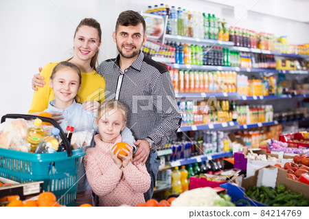 Nice parents with two girls choosing fruits Nice parents with two girls choosing fruits 84214769