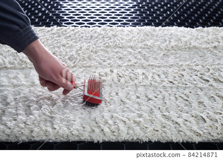 Cleaning wet carpet with metal brush in cleaning service Cleaning wet carpet with metal brush in cleaning service 84214871
