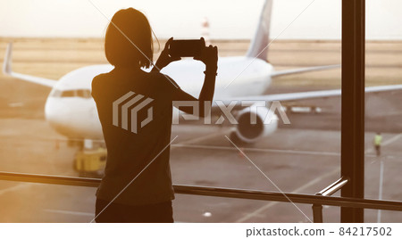 Girl takes a photo of the airplane. Girl takes a photo of the airplane. 84217502