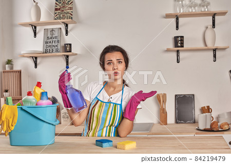 Beautiful cheerful brunette woman in gloves cleaning modern kitchen 84219479