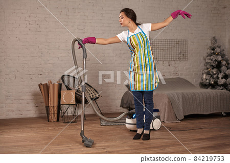 Happy woman cleaning home,dancing with vacuum cleaner and having fun, copy space. 84219753