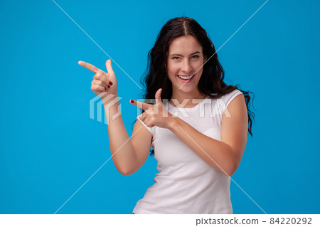 Woman making gun gesture on blue background Woman making gun gesture on blue background 84220292