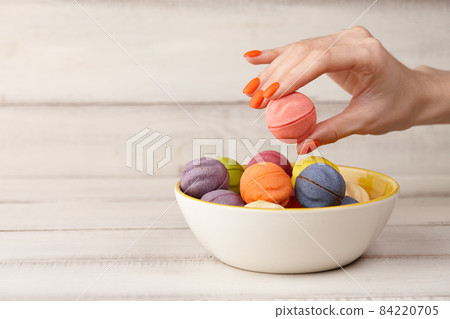 Woman taking color cookies from bowl, hands close up 84220705