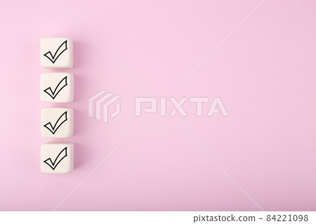 Four black checkmarks on white toy cubes in a row against bright pastel purple background with copy space Four black checkmarks on white toy cubes in a row against bright pastel purple background with copy space 84221098