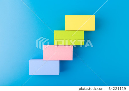Business development concept. Ladder made of multicolored rectangles with space for text against blue background 84221119