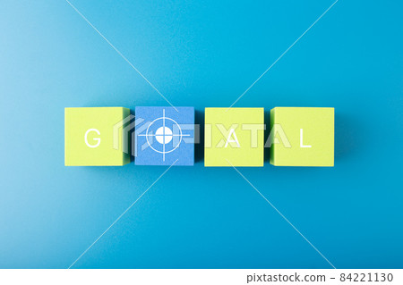 Goal single word and target symbol written on green and yellow geometric figures in a row on blue background Goal single word and target symbol written on green and yellow geometric figures in a row on blue background 84221130