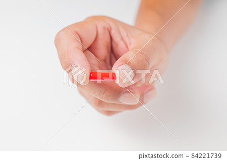Hands of a man holding a capsule-shaped drug Hands of a man holding a capsule-shaped drug 84221739