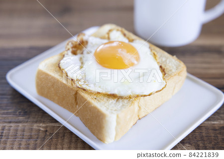 Delicious fried egg topped with thick sliced bread toast and hot coffee 84221839