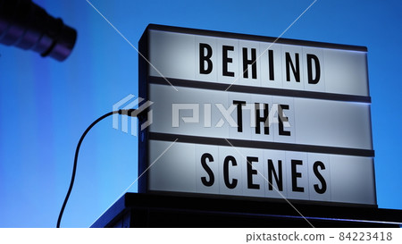 Behind the scenes text on Lightbox or Cinema Light box. Movie board light box on studio stair and light Snoot tripod on colors gradiant Background. Represent behind the scenes team is working on. Behind the scenes text on Lightbox or Cinema Light box. Movie board light box on studio stair and light Snoot tripod on colors gradiant Background. Represent behind the scenes team is working on. 84223418
