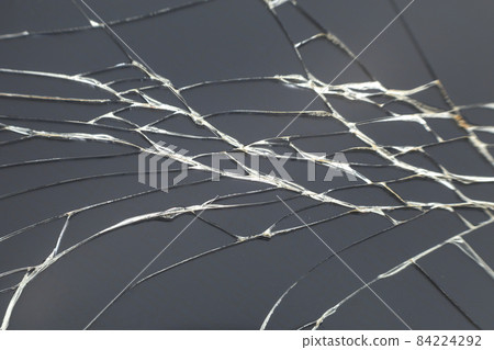 Abstract pattern dark gray background. Crackled screen of mobile cellphone. Gadget repair and maintenance concept. Abstract pattern dark gray background. Crackled screen of mobile cellphone. Gadget repair and maintenance concept. 84224292