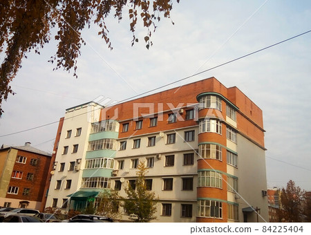 The brown facade of an unusual five-storey house against the background of the autumn sky The brown facade of an unusual five-storey house against the background of the autumn sky 84225404