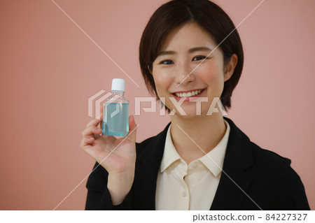 Female with mouthwash 84227327
