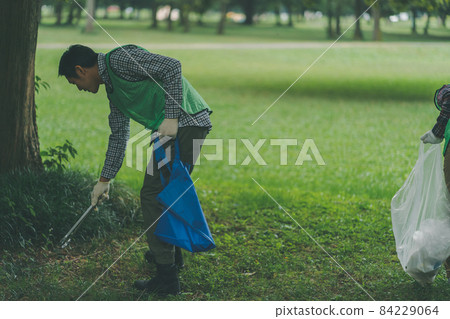 Volunteer picking up trash 84229064