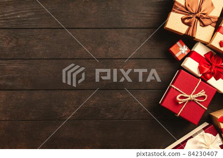 Christmas background with gift boxes on wooden table Christmas background with gift boxes on wooden table 84230407