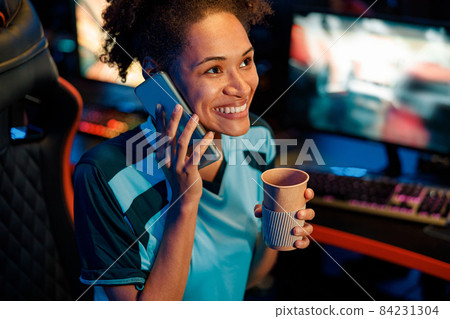 Woman gamer uses cellphone in cyber club Woman gamer uses cellphone in cyber club 84231304