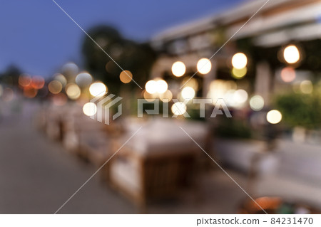 Abstract blured defocused image of European cosy cafe at dusk with beautiful bokeh lights. Great backdrop for your design. Travel concept. Copy space. 84231470