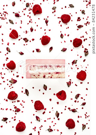 Top view of delicious litchi and raspberry mousse cake slice with the layers displayed and recipe ingredients arranged over white background. Restaurant menu and confectionery concept in flat lay 84231478