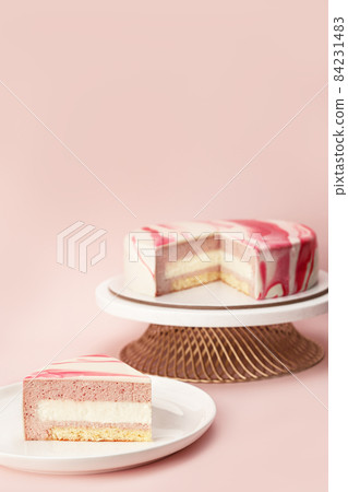 Delicious strawberry mousse cake on a stand and slice with the layers and texture displayed on lilac background. Restaurant menu and confectionery concept. Close-up. Copy space. Delicious strawberry mousse cake on a stand and slice with the layers and texture displayed on lilac background. Restaurant menu and confectionery concept. Close-up. Copy space. 84231483