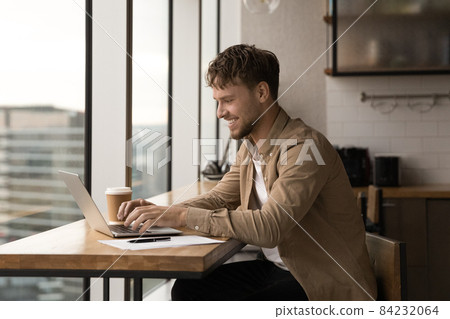 Happy young caucasian man working on computer. Happy young caucasian man working on computer. 84232064