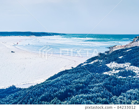 Winter wonderland and Christmas fantasy landscape. Frozen sea coast and mountains covered with snow as holiday background Winter wonderland and Christmas fantasy landscape. Frozen sea coast and mountains covered with snow as holiday background 84233012